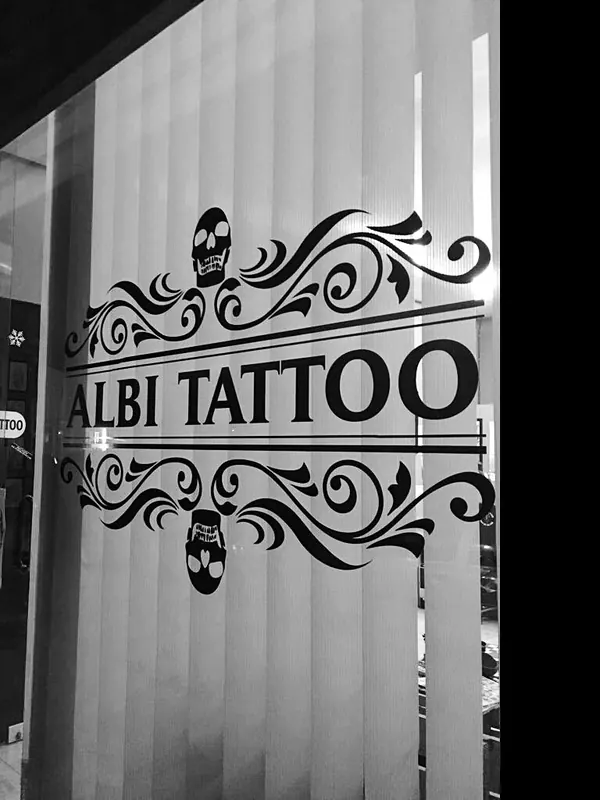 The Albi Tattoo logo on the studio's glass door