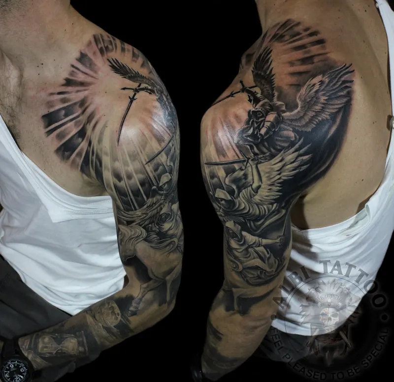 Black and grey shoulder pieces with an archangel, wings and light rays